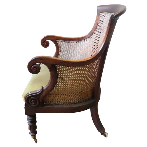 72 - AN ELEGANT MAHOGANY WILLIAM IV BERGERE LIBRARY CHAIR, arched scrolling top rail over a caned back pa... 