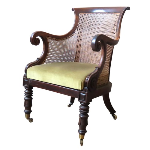 72 - AN ELEGANT MAHOGANY WILLIAM IV BERGERE LIBRARY CHAIR, arched scrolling top rail over a caned back pa... 