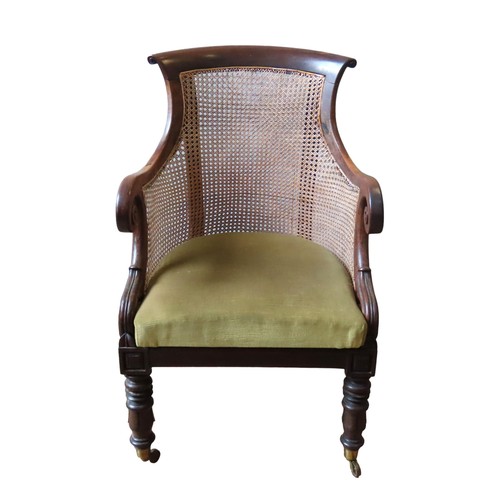 72 - AN ELEGANT MAHOGANY WILLIAM IV BERGERE LIBRARY CHAIR, arched scrolling top rail over a caned back pa... 