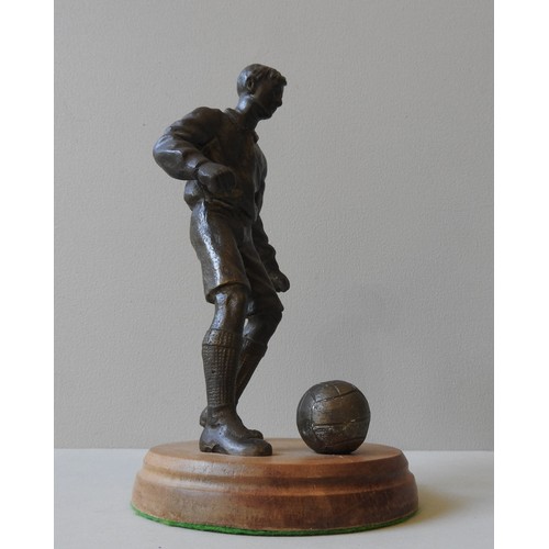 582 - A BRONZE FIGURE OF A FOOTBALL PLAYER, MID 20TH CENTURY, modelled naturalistically, about to strike t... 