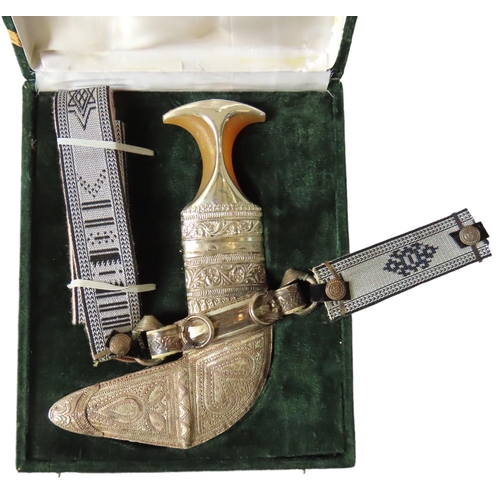 228 - A SILVER MOUNTED OMANI KHANGAR, with ornate scabbard, belt and presentation box, presented to a Brit... 