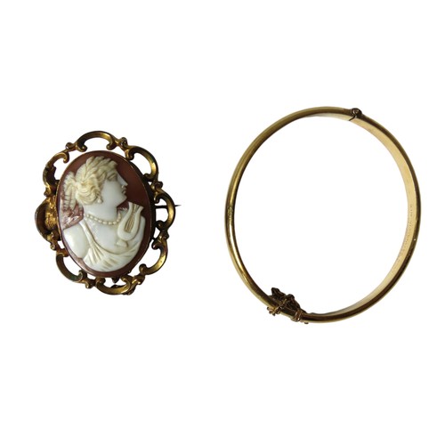 604 - AN OVAL PORTRAIT CAMEO BROOCH AND SLAVE BANGLE, the cameo in an ornate scroll work mount stamped 9ct... 