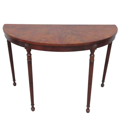 28 - A FIGURED MAHOGANY DEMI LUNE TABLE, 19TH CENTURY, raised on four slender turned fluted legs, termina... 