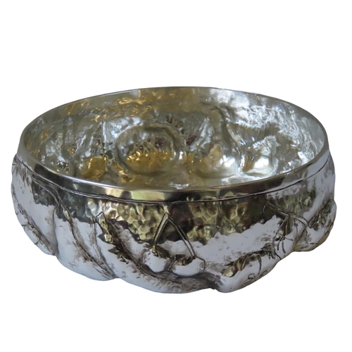 675 - A HAMMERED WHITE METAL FRUIT BOWL, the sides with repousse decoration depicting various fruits11 cm ... 