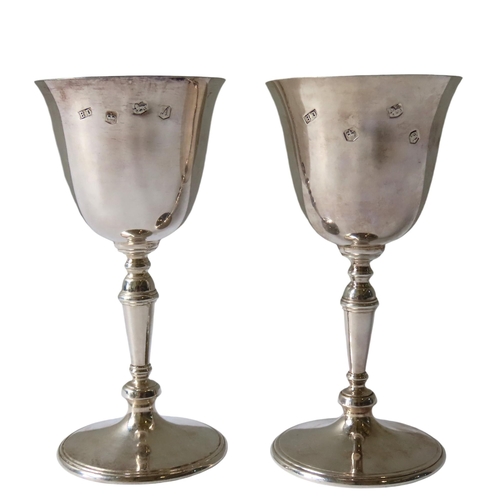 685 - A PAIR OF VINTAGE SILVER GOBLETS, the flared edge bowls raised on knop turned tapering stems, on a c... 