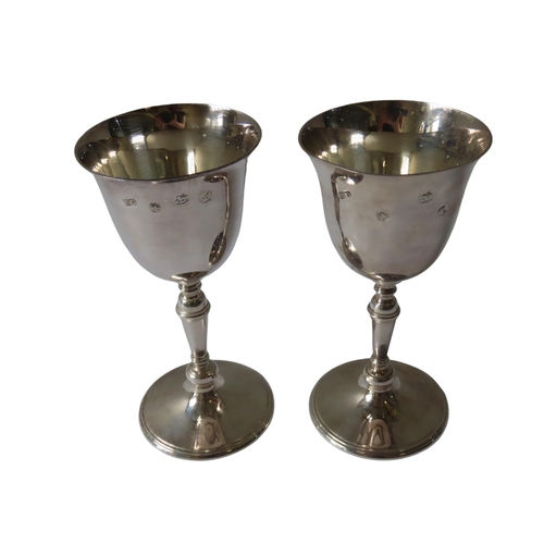 685 - A PAIR OF VINTAGE SILVER GOBLETS, the flared edge bowls raised on knop turned tapering stems, on a c... 