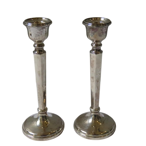 647 - A PAIR OF VINTAGE WEIGHTED SILVER CANDLESTICKS, the sconces raised on hexagonal tapering pillars, on... 