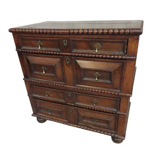 49 - AN OAK PANELLED ATTIC CHEST OF DRAWERS, rectangular top with bobbin turned edge over four alternatin... 