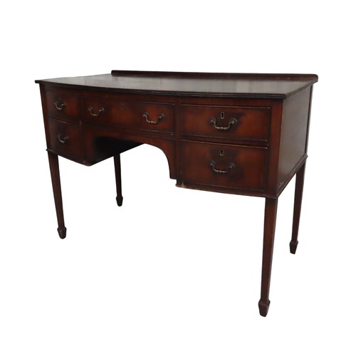 37 - A LATE 19TH CENTURY MAHOGANY WRITING DESK, bow front form, with a long frieze drawer flanked by four... 