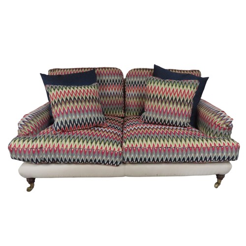 81 - A CONTEMPORARY TWO SEAT HOWARD-STYLE SETTEE, the calico covered frame with twin arch back panel the ... 