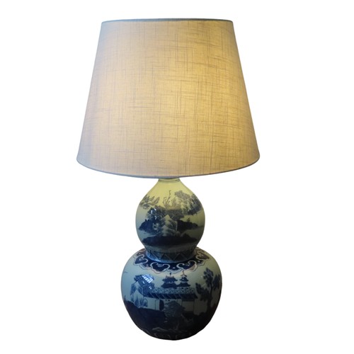 313 - A CHINESE-STYLE BLUE AND WHITE DOUBLE GOURD TABLE LAMP decorated with a palace and rural landscape s... 