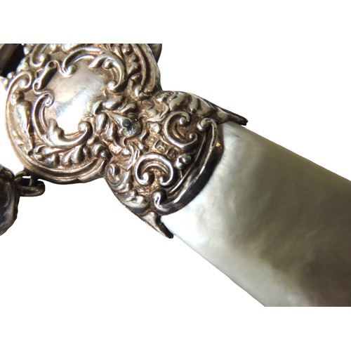 633 - AN EDWARDIAN SILVER MOUNTED BABY'S RATTLE, with mother of pearl handle, the silver mount with repous... 