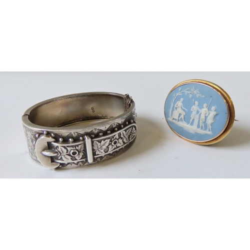 605 - A SILVER WIDE CUFF BUCKLE BANGLE AND WEDGWOOD BROOCH, the chased bangle marked Birmingham 1884, the ... 