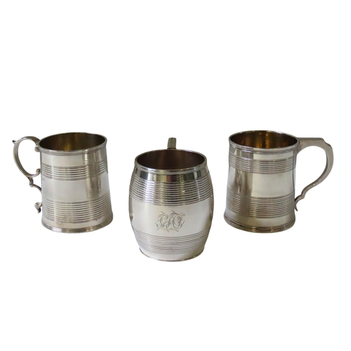 701 - A GEORGE III SILVER MUG AND TWO WILLIAM IV SILVER MUGS, all three with bands of turned concentric de... 