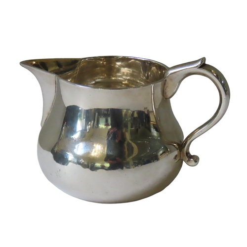 695 - AN ELEGANT 19TH CENTURY IRISH SILVER JUG, waisted baluster form with scroll handle and sparrow beak ... 