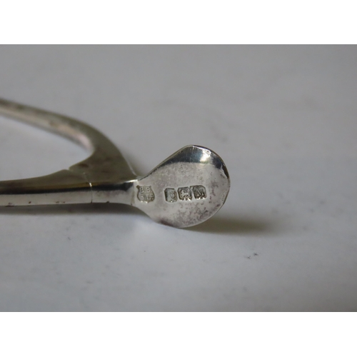 640 - AN UNUSUAL PAIR OF SILVER SUGAR TONGS IN THE FORM OF A WISHBONE, together with two silver thimbles, ... 