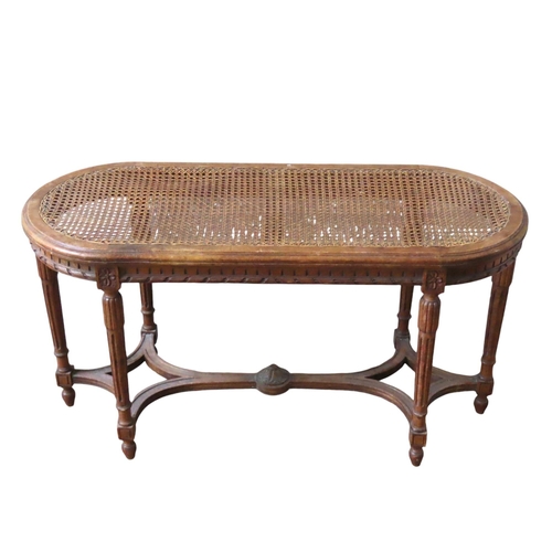 42 - A LOUIS XVI STYLE CANE TOP PIANO STOOL, LATE 19TH CENTURY, the curved end rectangular top raised on ... 