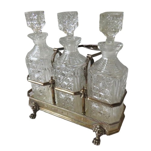 706 - A VICTORIAN SILVER DECANTER STAND, with three square form cut glass decanters, the stand with a bead... 