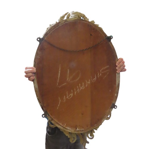 208 - A REGENCY STYLE OVAL WALL MIRROR, the oval plate in a beaded edge gilt gesso frame, surmounted by a ... 