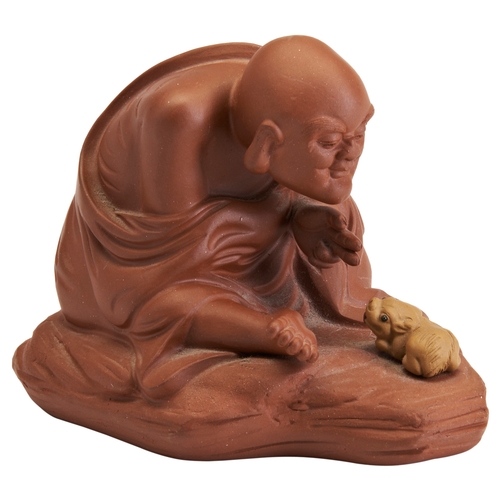 105 - A YIXING MODEL OF A MONK AND A SMALL RECUMBENT RAM20TH CENTURY宜兴罗汉摆件 20世纪the figure seated and hunch... 