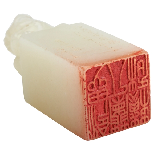 302 - A PALE CELADON JADE SEAL SURMOUNTED BY A BUDDHIST SEATED LION20TH CENTURY青白玉狮钮印  20世纪inscribed su he... 