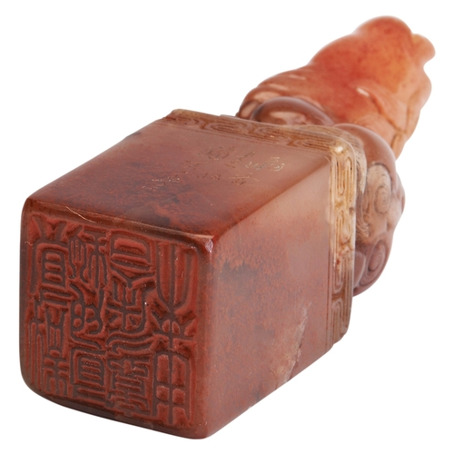 304 - A CARVED 'CHERRY-BLOSSOM' STONE SEALQING DYNASTY (1644-1911)寿山石桃花冻狮钮印 清(1644-1911)surmounted by a se... 