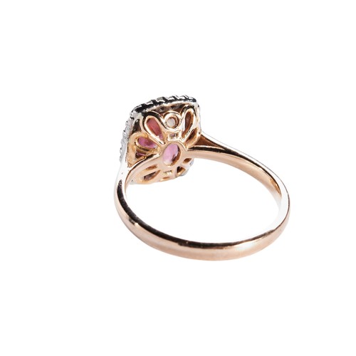 308 - A MORGANITE AND DIAMOND RING, the oval mixed-cut morganite, four claw set withtin a bezel of brillia... 