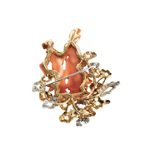 247 - A CORAL GOLD AND DIAMOND BROOCHthe coral figures within a diamond set two tone metal mount.Brooch pi... 