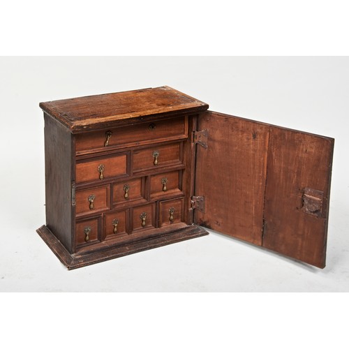 23 - A CHARLES II OAK SPICE CUPBOARDLATE 17TH CENTURYthe mitre moulded door enclosing an arrangement of d... 