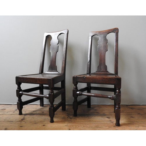 1 - A PAIR OF 18TH CENTURY OAK CHAIRS, with fiddle backs, on turned square form legs united by stretcher... 