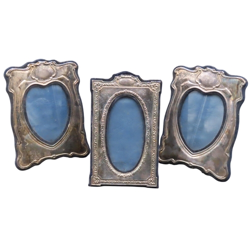 334 - A PAIR OF SILVER MOUNTED PHOTO FRAMES, with scrolling cartouche decoration and heart shaped panels, ... 