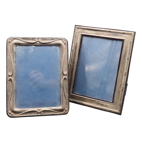 335 - TWO SILVER MOUNTED PHOTO FRAMES, one scroll decorated frame and one fluted edge frame, both on easel... 