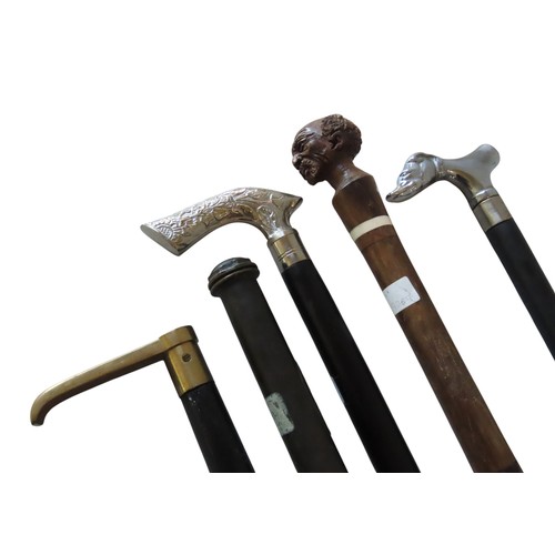 253 - A MIXED GROUP OF FOUR WALKING CANES, including a carved hardwood bone inset cane, a compass inset ca... 