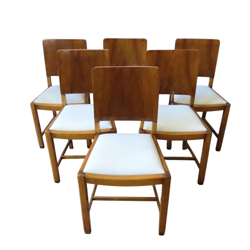 49 - AN ART DECO WALNUT DINING TABLE AND SIX CHAIRS, CIRCA 1935, the rectangular top with graduated edge ... 