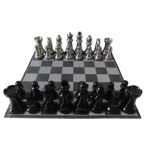 428 - A CONTEMPORARY OVERSIZED CERAMIC CHESS SET, with silver and black coloured pieces, on a slate games ... 