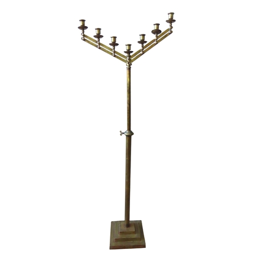 94 - AN ECCLESIASTIC BRASS CANDELABRUM, comprised of seven sconces sat atop pivoting twin branches, on an... 