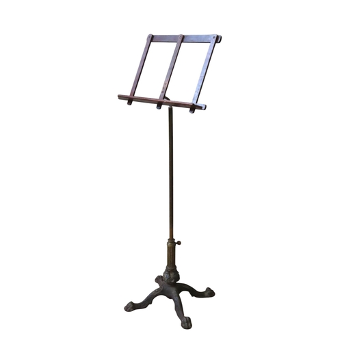 91 - A VINTAGE BRASS AND CAST-IRON SHEET MUSIC STAND, the folding easel stand on an adjustable fluted bra... 