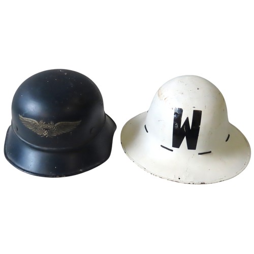 144 - A GERMAN WWII LUFTSCHUTZ HELMET AND A BRITISH AIR WARDEN HELMET, the German helmet with winged swast... 