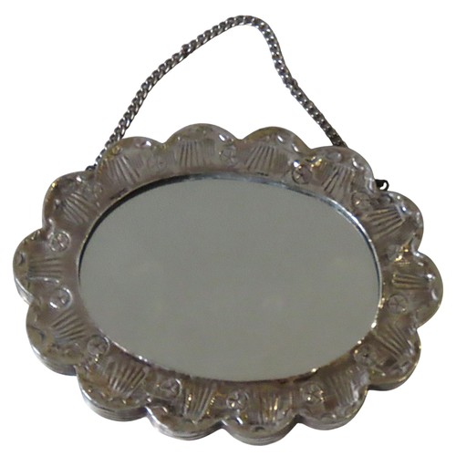 336 - A TURKISH SILVER MOUNTED MIRROR, oval form with scalloped edge, the back with intricate repousse dec... 