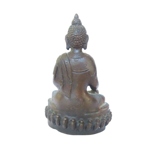 507 - A CAST BRONZE FIGURE OF BUDDHA, modelled in flowing robes, seated cross legged on a lotus form base1... 