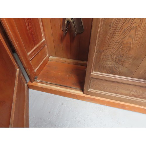 25 - A LARGE PINE BIBLIOTHEQUE, ogee cornice over three part glazed cabinet doors, raised on a plinth bas... 