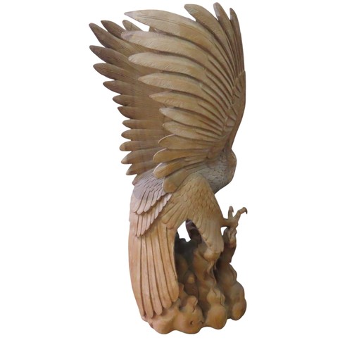 24 - A VERY LARGE IMPRESSIVE CARVED PINE EAGLE, modelled taking flight from a rocky outcrop, with wings s... 