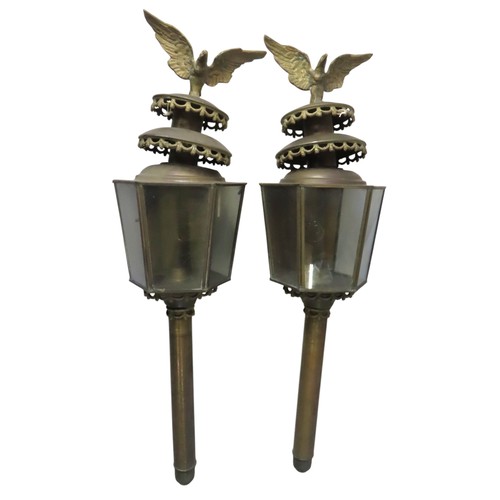 67 - A PAIR OF GILT BRASS CARRIAGE LAMPS, of tapering hexagonal form, surmounted by models of eagles72.5 ... 