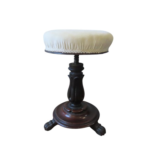 95 - A VICTORIAN REVOLVING PIANO STOOL, the buttoned circular seat raised on a stiff leaf carved column, ... 