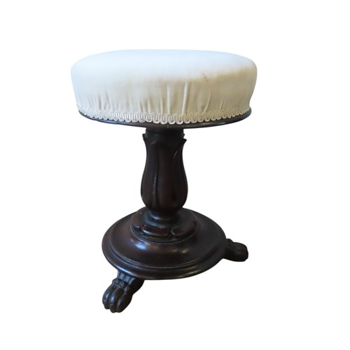 95 - A VICTORIAN REVOLVING PIANO STOOL, the buttoned circular seat raised on a stiff leaf carved column, ... 