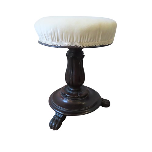 95 - A VICTORIAN REVOLVING PIANO STOOL, the buttoned circular seat raised on a stiff leaf carved column, ... 