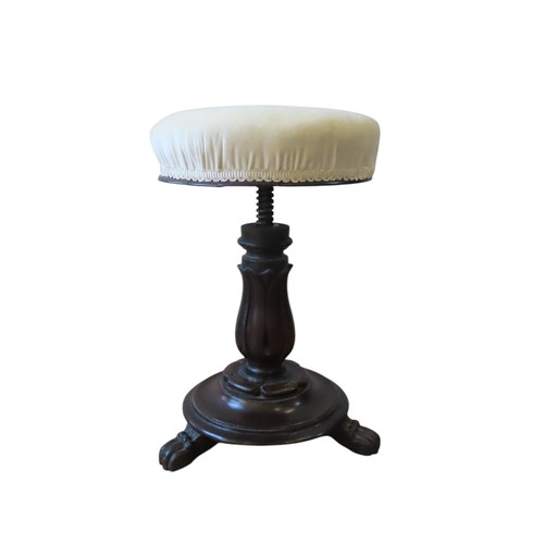 95 - A VICTORIAN REVOLVING PIANO STOOL, the buttoned circular seat raised on a stiff leaf carved column, ... 