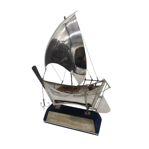 A STERLING SILVER MODEL DHOW, with Sharjah House mark to the sail, and ...