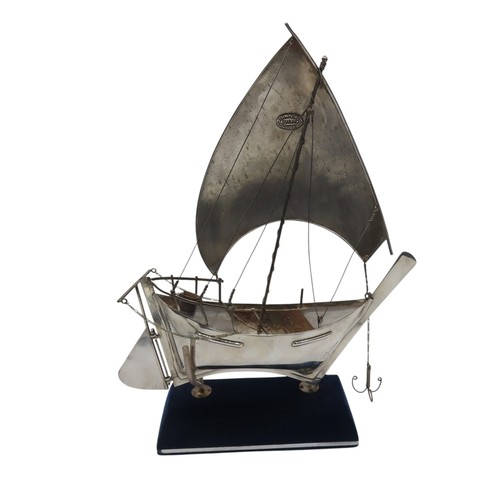 A STERLING SILVER MODEL DHOW, with Sharjah House mark to the sail, and ...