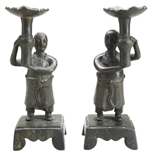 111 - A PAIR OF CHINESE BRONZE FIGURAL CANDLESTICKS CIRCA 1880 each modelled as a robed male holding aloft... 